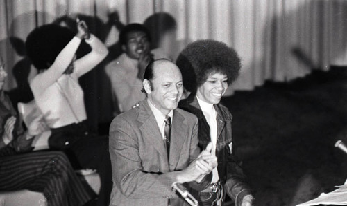 Leo Branton Jr. applauding as he stands on stage at the Embassy Auditorium, Los Angeles, 1972