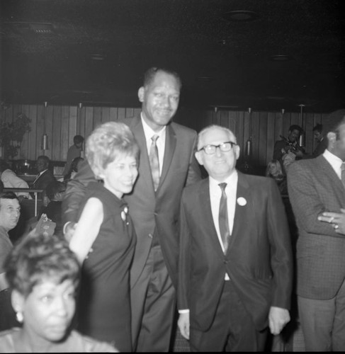 Tom Bradley posing with a couple at a mayoral campaign event, Los Angeles, 1969