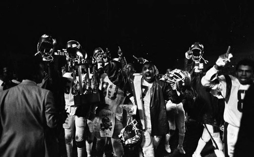 Dorsey High School football team holding the city 3-A championship trophy, Los Angeles, 1982