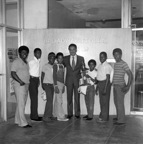 Elbert T. Hudson posing with the Broadway Braves and their trophy, Los Angeles, 1974