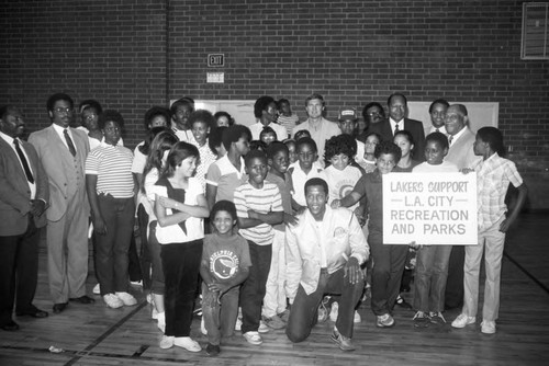 Jamaal Wilkes posing with children and adults at the Harvard Recreation Center, Los Angeles, 1989