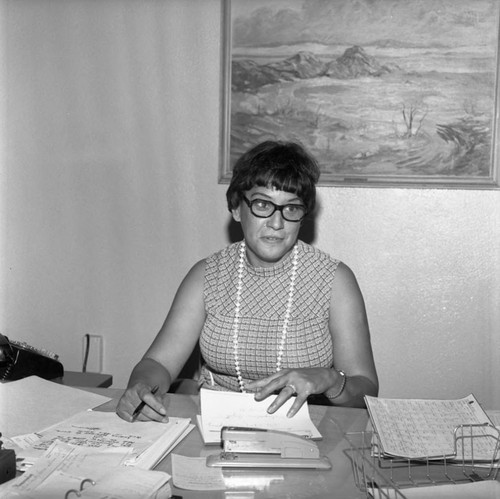 Enterprise School staff member sitting at her desk, Los Angeles, ca. 1965