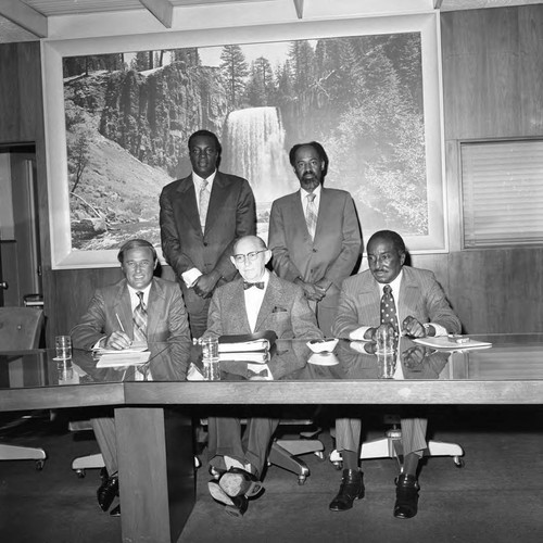 Dr. Abel B. Sykes, Jr. posing with others in a Compton College meeting room, Compton, 1972