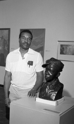 Dr. David Driskell posing next to a sculpture, Los Angeles, 1986