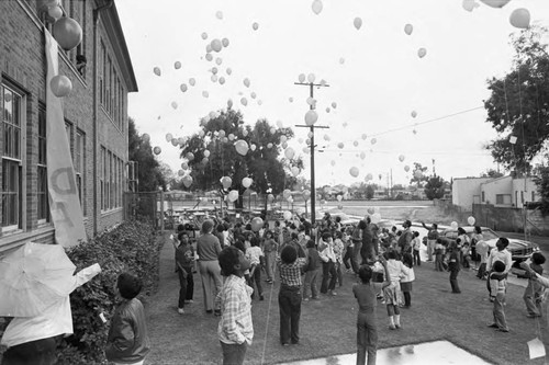 Ritter Elementary School children watching the release of balloons, Watts (Los Angeles, Calif.), 1983