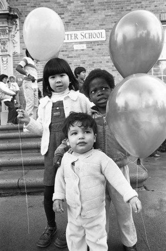 Children holding balloons at Ritter Elementary School, Watts (Los Angeles, Calif.), 1983