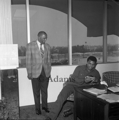 Ali sits at a desk, Los Angeles, 1972