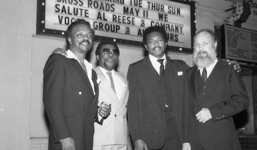 Al Reese posing with band members by a marquee, Los Angeles, 1987