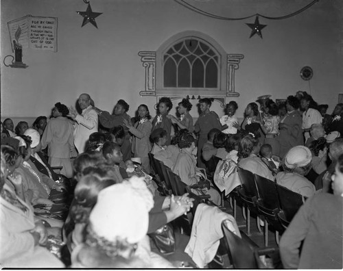 Bishop Charles Manuel "Sweet Daddy" Grace leading his congregation in worship, Los Angeles, 1950