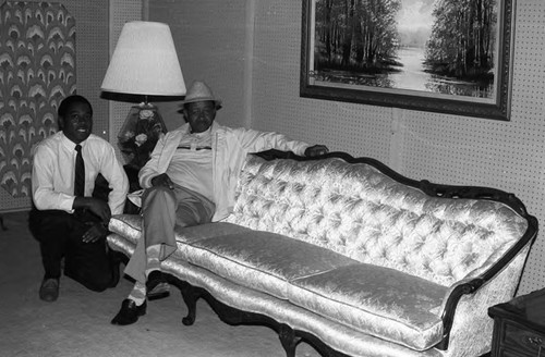 Clark Furniture Store staff member posing with a man in the showroom, Los Angeles, 1984