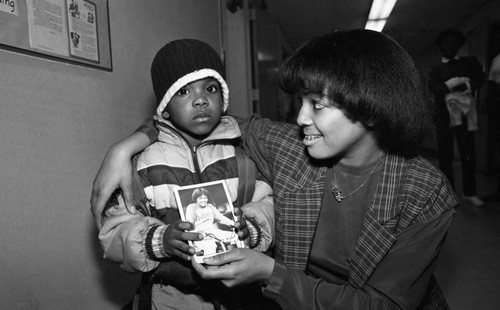 Kim Fields giving a photograph to a child at Weemes Elementary School, Los Angeles, 1983