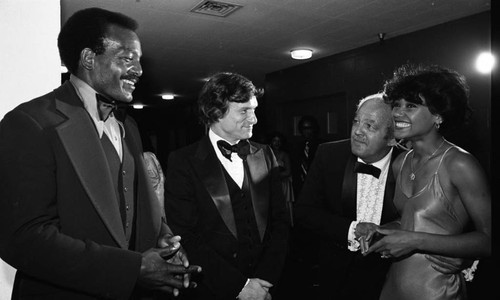 Jim Brown and Hugh Hefner talking with Kellee Patterson at the NAACP Image Awards, Los Angeles, 1978