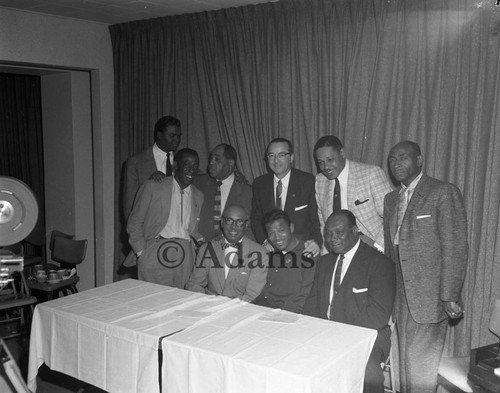 Men gather at table, Los Angeles, 1956