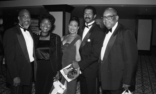 Howard Bingham, Telma Hopkins, and Brad Pye, Jr. posing with others at "A Midsummer Night's Magic" dinner, Los Angeles, 1995