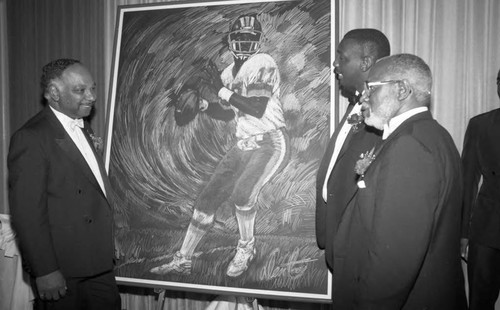 Doug Williams receiving a painting from Edward Hubbard and Eugene Wheeler during a 100 Black Men tribute, Los Angeles, 1988