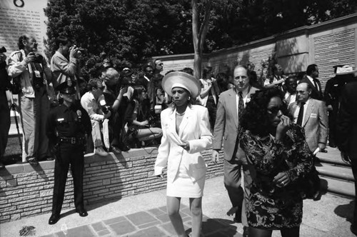 Mourners walking past photographers at Sammy Davis Jr.'s funeral service, Glendale, California, 1990