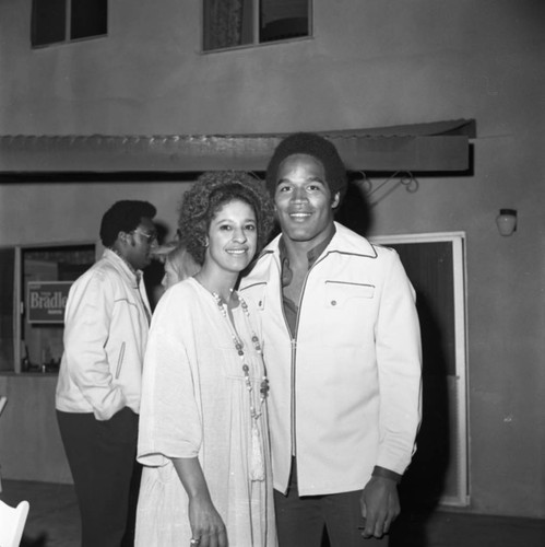 O.J. Simpson posing with a woman at a Bradley campaign event, Los Angeles, 1973