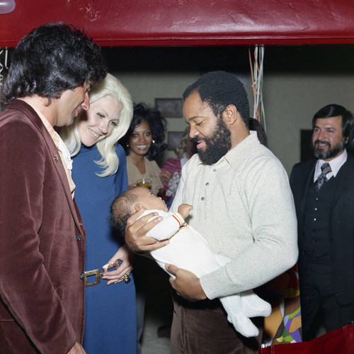 Berry Gordy holding a baby, Los Angeles, 1971