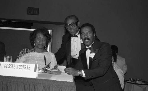 Rev. Cecil L. Murray posing with Robert Hooks and Dessie Roberts during the First AME Church mortgage retirement party, Los Angeles, 1986