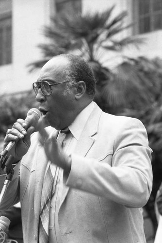 Bishop H. H. Brookins addressing a crowd in front of City Hall, Los Angeles, 1986