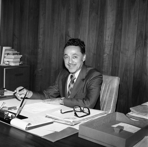 Elbert Hudson sitting at his desk, Los Angeles