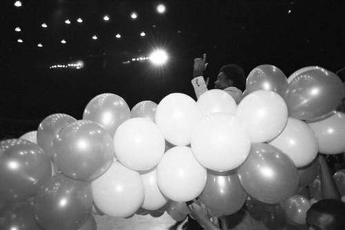 Young man standing among balloons at a LAUSD Band and Drill Team Championship, Los Angeles, 1983