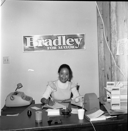 Bradley campaign staff member posing at a desk, Los Angeles, 1973