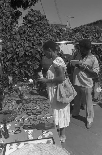 Woman viewing jewelry at the African Market Place, Los Angeles, 1987