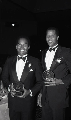 O.J. Simpson and Jamaal Wilkes holding awards from the Boys' Club of America, Los Angeles, 1987