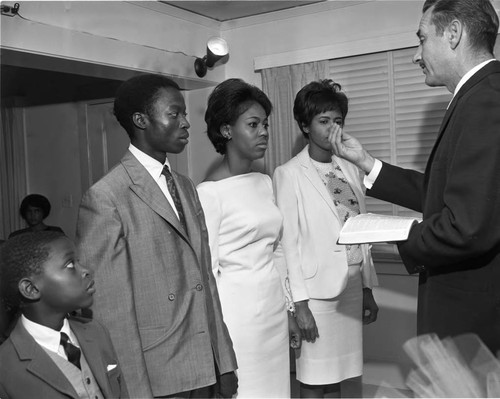 Bride and groom listening to the officiant during their wedding ceremony, Los Angeles, 1965