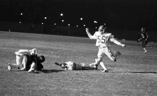 Crenshaw High School football placekicker completing a play, Long Beach, California, 1982