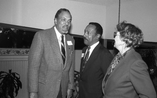 Reginald A. Dunn speaking with others at an event in a private home, Los Angeles, 1996