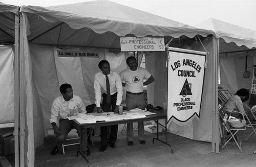 Black Agenda Business Fair participants standing in their booth, Los Angeles, 1983