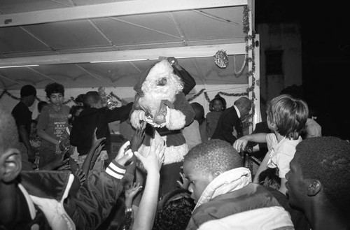 Christmas tree lighting ceremony's Santa distributing gifts, Los Angeles, 1989