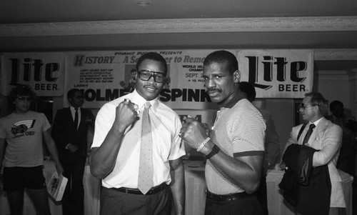 Larry Holmes and Michael Spinks posing together during a press conference, 1985