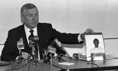 Chief Rasberm displaying a mug shot at a press conference, Los Angeles, 1989