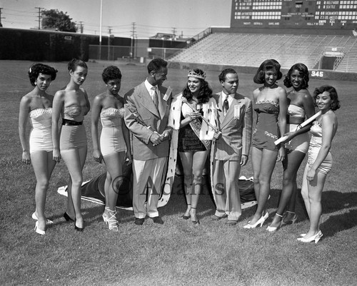 Charles Williams standing with the Queen of the Cavalcade of Jazz and her court at Wrigley Field, Los Angeles, 1952