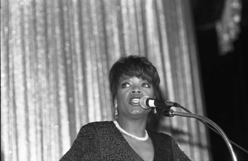 Oprah Winfrey speaking from a lectern at the Hollywood Paladium, Los Angeles, 1989
