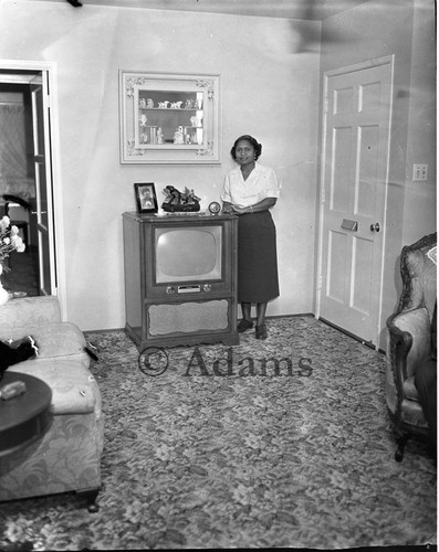 Woman stands next to TV set, Los Angeles, 1955