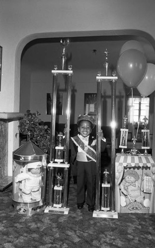 Marquise W. Richardson posing with trophies, Los Angeles, 1987