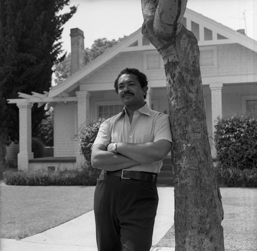 Mervyn Dymally posing in front of his home, Los Angeles, 1973