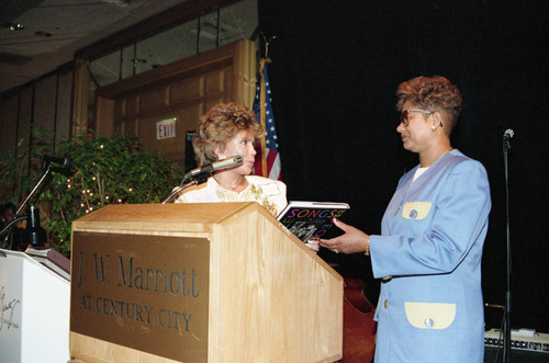 Iris Rideau presenting a book to Evelina Williams, Los Angeles, 1992