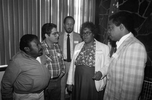 Press conference attendees talking together, Los Angeles, 1984