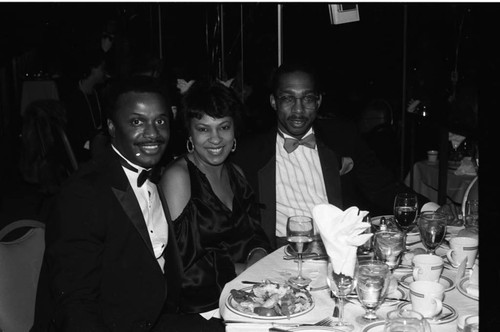 Guests posing at a table during a dinner for Tom Bradley, Los Angeles, 1989