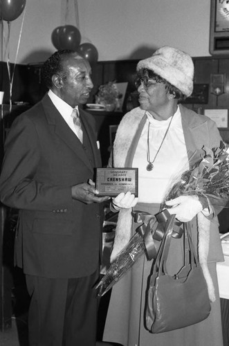 Crenshaw Chamber of Commerce representative presenting an award to Mrs. Campbell, Los Angeles, 1985