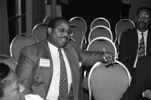 Business conference participant speaking from his seat during a presentation, Los Angeles, 1994