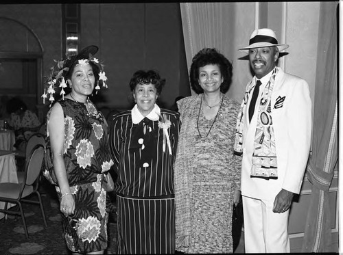 Three African American women and a man posing together in a ballroom, Los Angeles, 1986