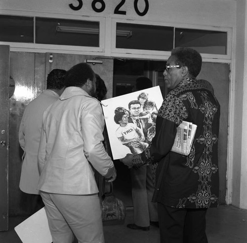 Booker Griffin examining a drawing of Muhammad Ali, Los Angeles, 1975