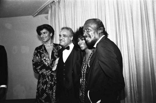 Jayne Kennedy, Benjamin Hooks, Cicely Tyson and Miles Davis standing together at the NAACP Image Awards, Los Angeles, 1981