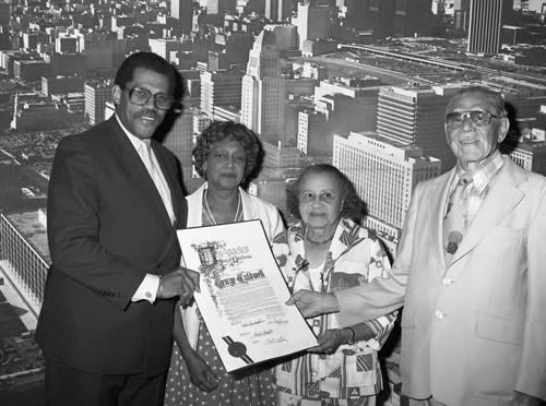 George Caldwell posing with David S. Cunningham, Jr. while holding a proclamation, Los Angeles, 1983